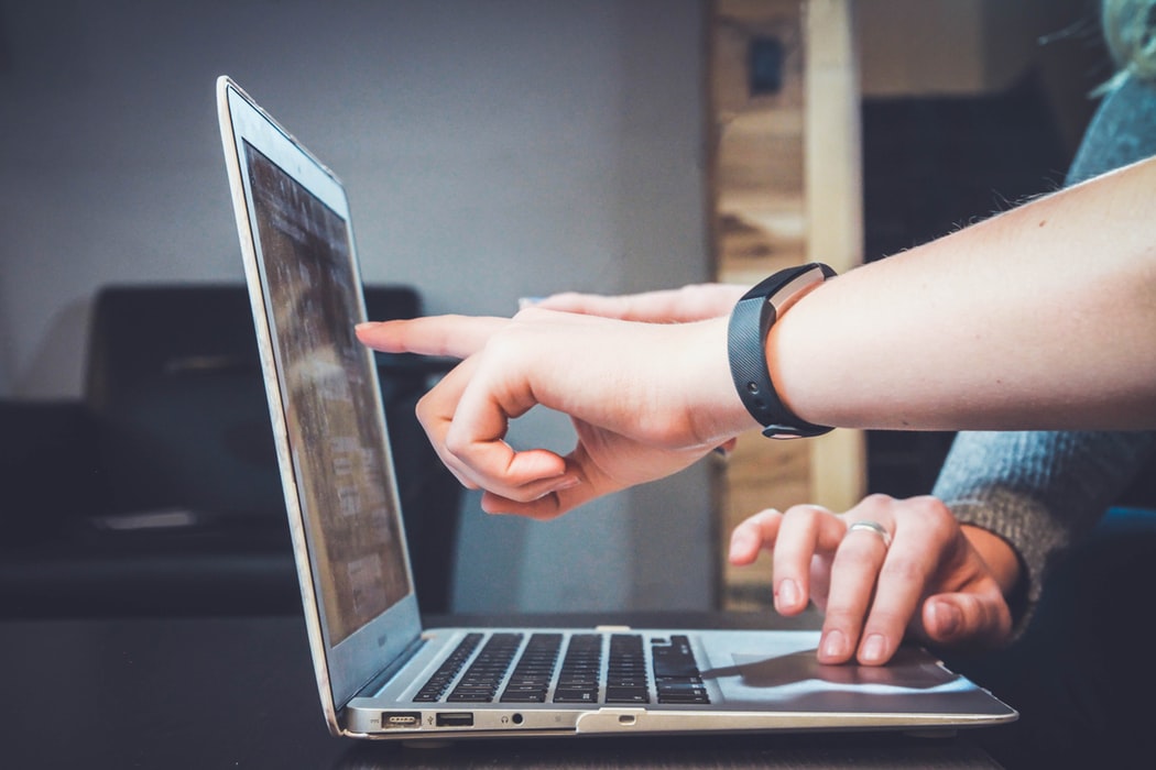 Picture of people pointing to a computer screen